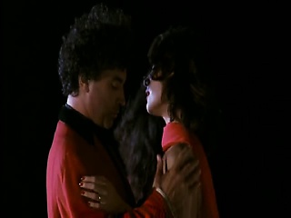 Claudia Koll standing exterior as a man pulls her white