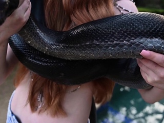 Redhead snake charmer poses nude outdoor